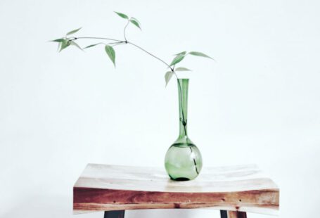 Becoming - green glass vase on brown wooden table