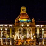 Grand Budapest Hotel - Aged palace with glowing lamps against night sky