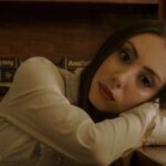 Midnight Library - A woman leaning on a desk in front of a bookcase