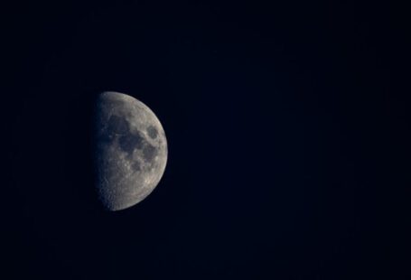 Dark Side Of The Moon - Minimalistic view of half moon with spots at cloudless dark sky at night