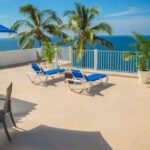 Handmaid's Tale - Blue Loungers on Beige Balcony Beside Sea Landscape Photography