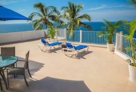 Handmaid's Tale - Blue Loungers on Beige Balcony Beside Sea Landscape Photography