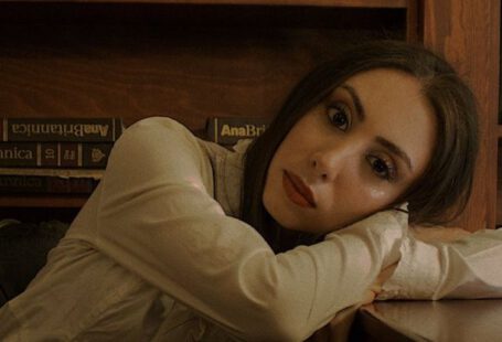 Midnight Library - A woman leaning on a desk in front of a bookcase