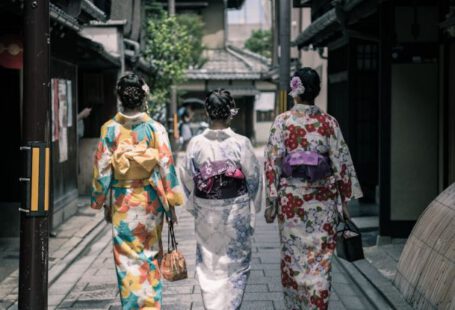 Kimono - Three Geisha Walking Between Buildings
