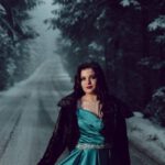 Silk Roads - Model Wearing a Turquoise Satin Dress Posing on a Forest Road in Winter at Dusk