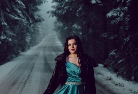 Silk Roads - Model Wearing a Turquoise Satin Dress Posing on a Forest Road in Winter at Dusk