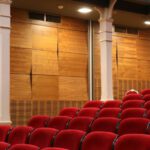 Phantom Of The Opera - Red Theater Chair Lot Near White Concrete Pillars