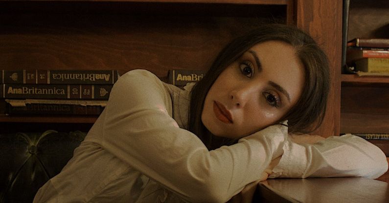 Midnight Library - A woman leaning on a desk in front of a bookcase